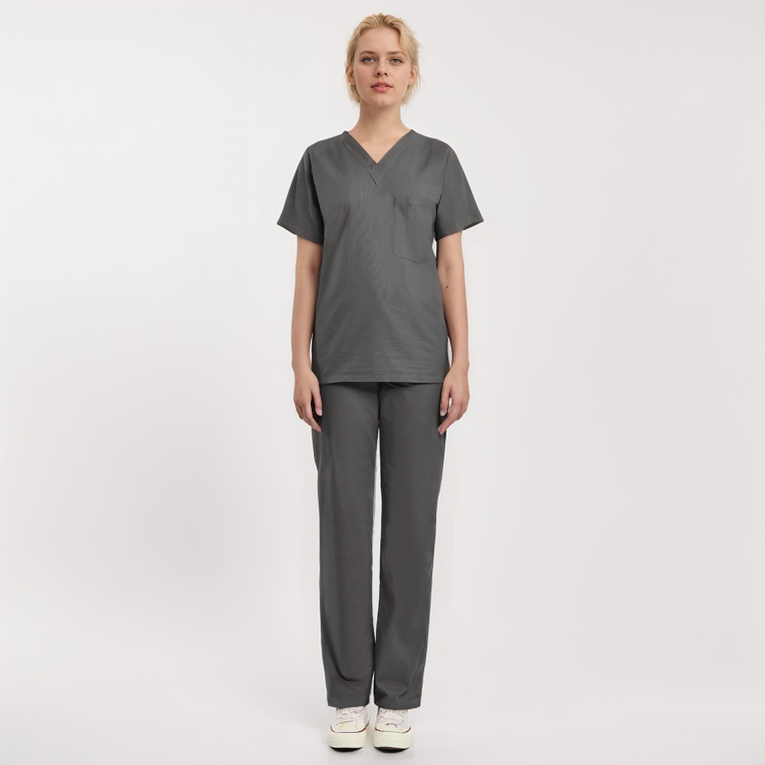 Front view of a model wearing a gray Scrub Unisex 1-Pocket V-Neck Scrub Top, ideal for healthcare workers.