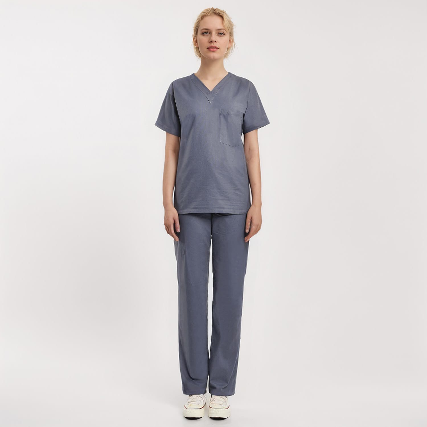 Front view of a model wearing a gray Scrub Unisex 1-Pocket V-Neck Scrub Top, ideal for healthcare workers.