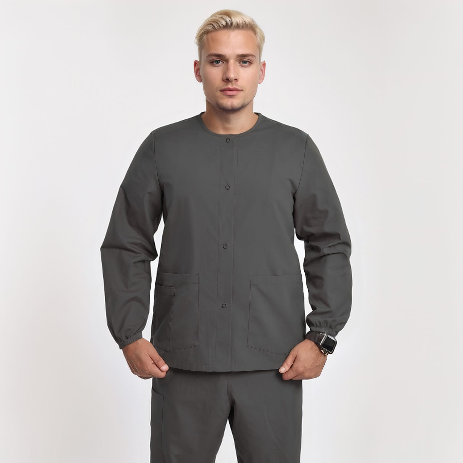 Front view of a model wearing a gray unisex 3-pocket warm-up scrub jacket with long sleeves, ideal for healthcare professionals.