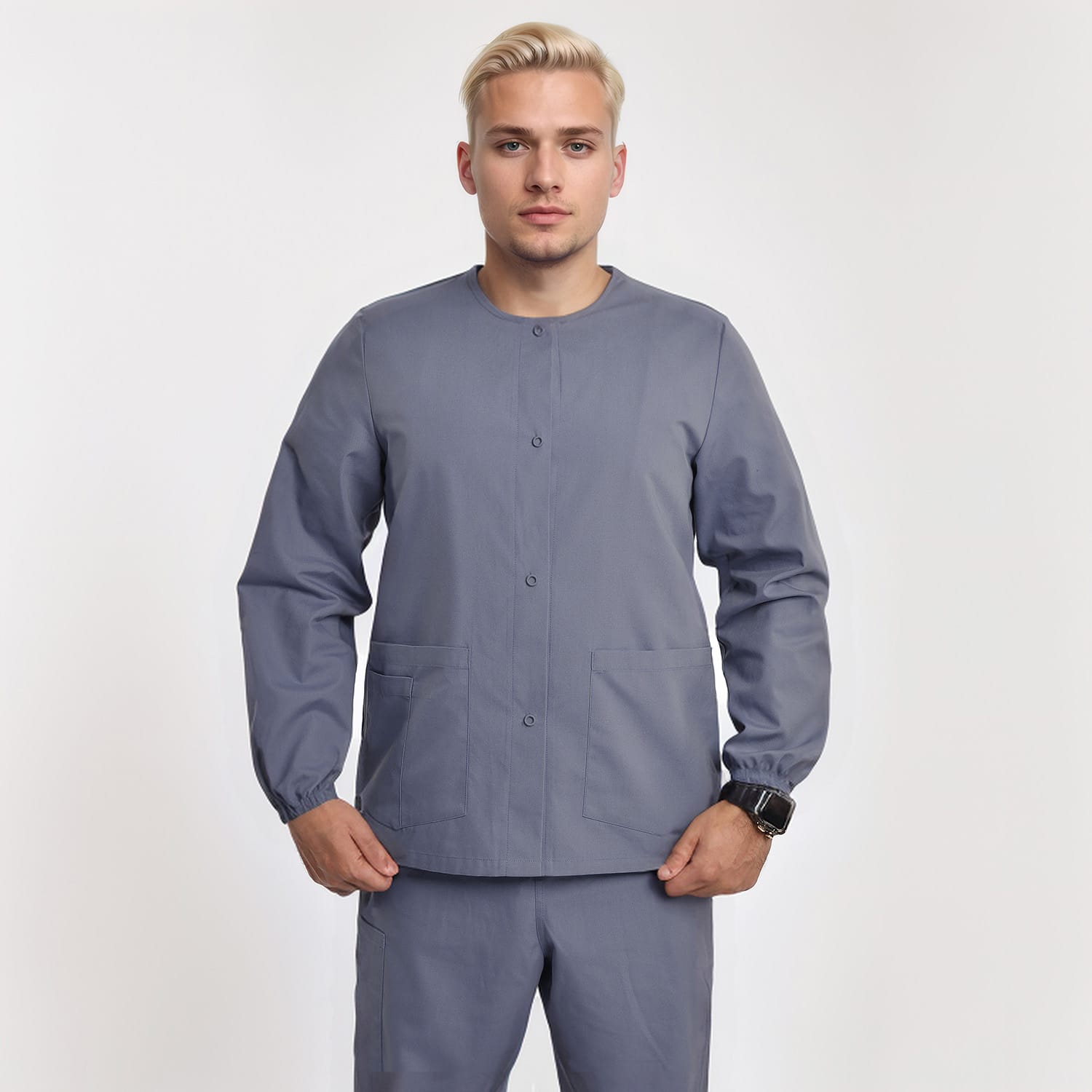 Front view of a model wearing a gray unisex 3-pocket warm-up scrub jacket with long sleeves, ideal for healthcare professionals.