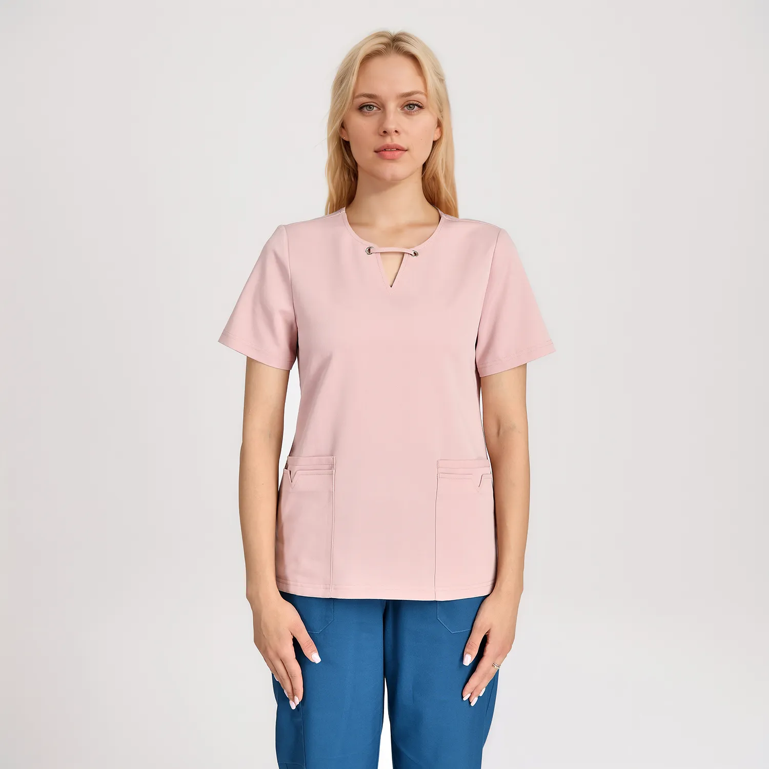 Close-up of a women's pink medical scrub top with a stylish collar, two front pockets, and short sleeves, perfect for healthcare professionals needing comfort and durability during work shifts.