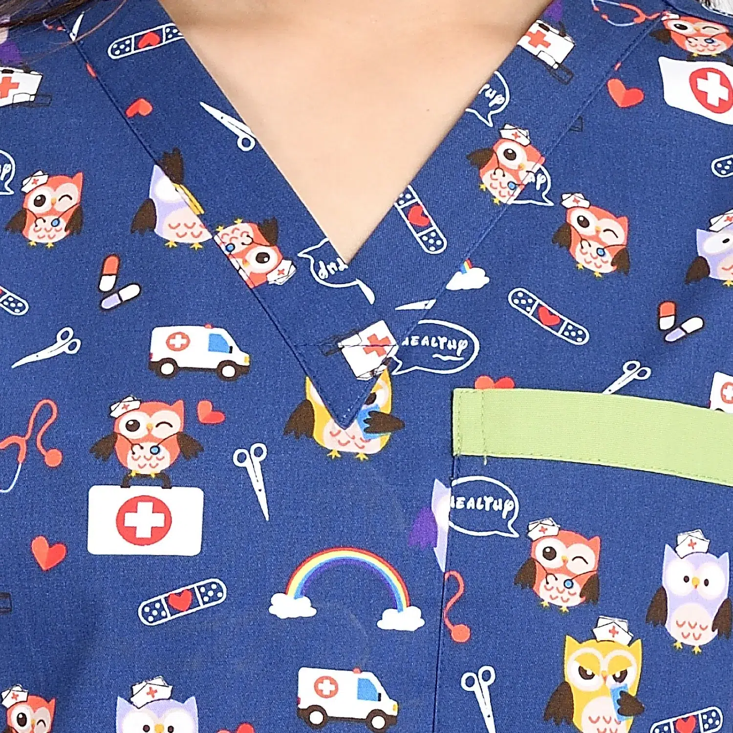 Close-Up of Cartoon Print Women’s Medical Scrub Top with V-Neck Design in Blue Close-up of a women's blue cartoon print scrub top with a V-neck design and a chest pocket, showcasing fun medical-themed illustrations.