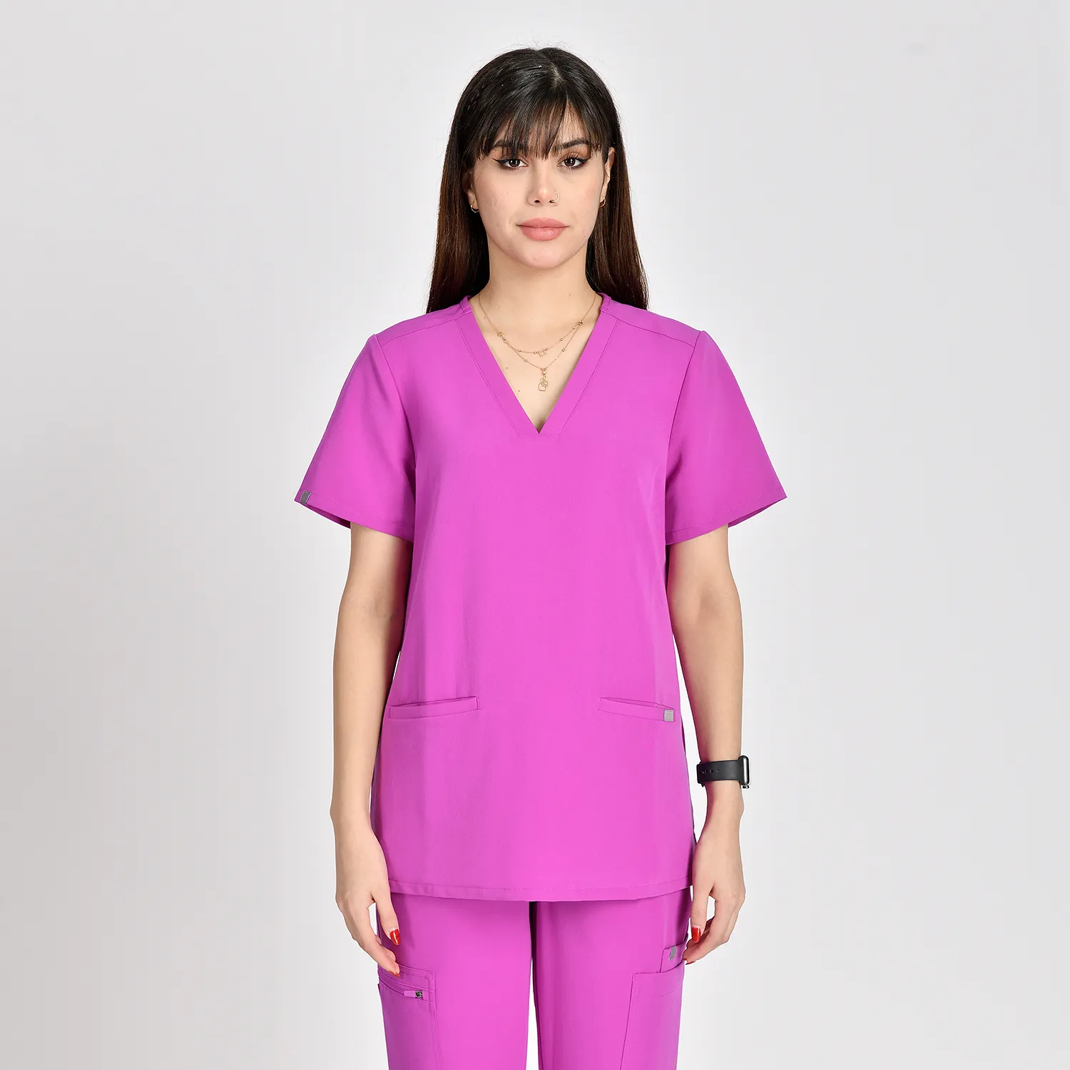 Women's purple V-neck scrub top with functional pockets, designed for comfort and style in medical work environments.