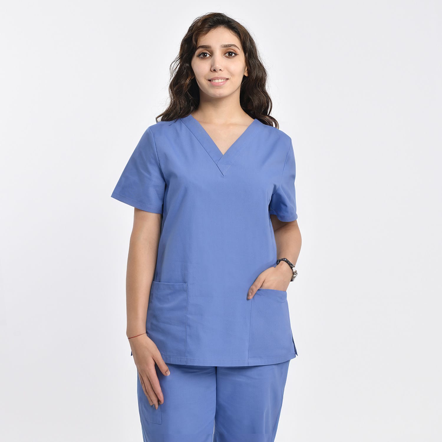 Front view of a model wearing a blue women’s 2-pocket V-neck scrub top, suitable for healthcare professionals.