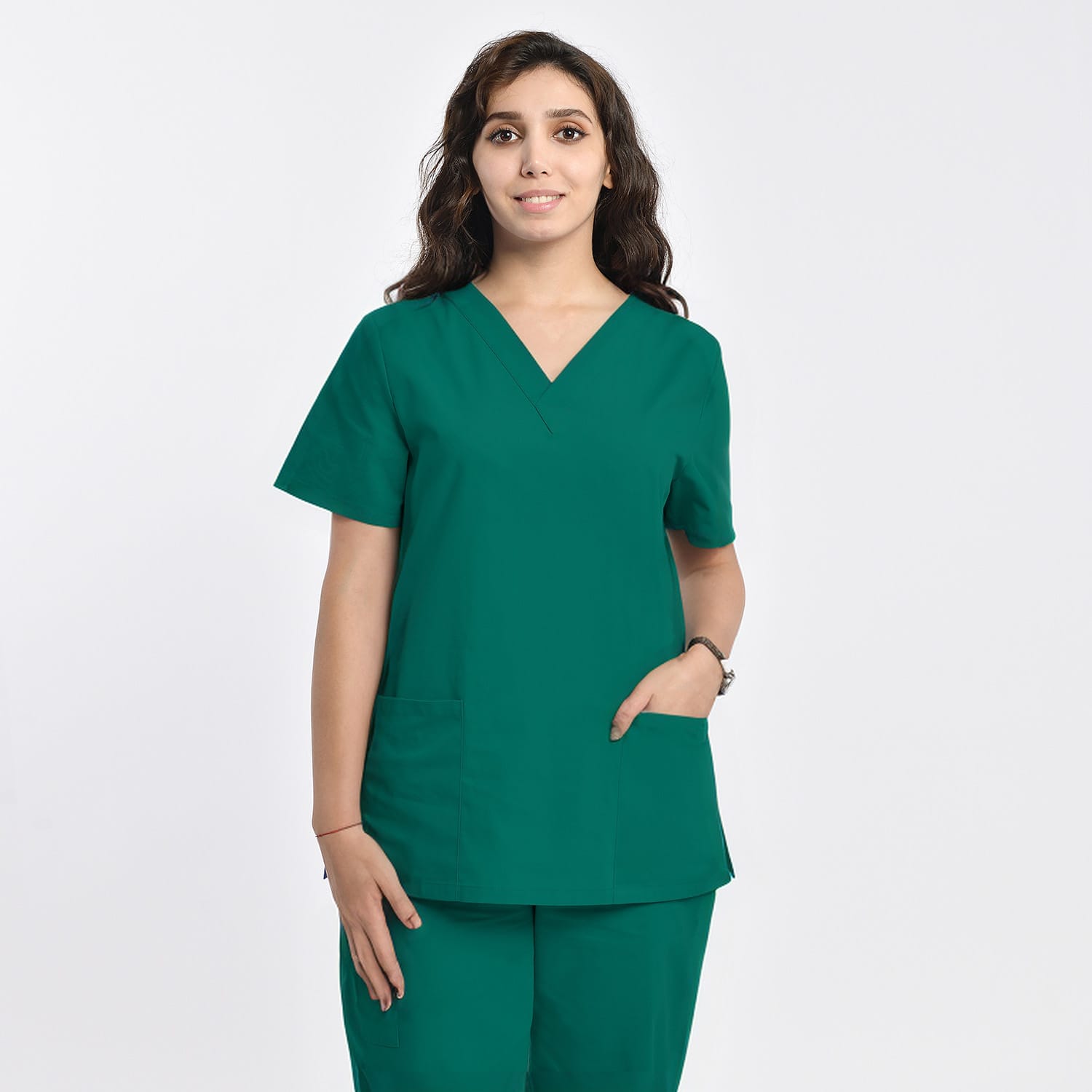Front view of a model wearing a green women’s 2-pocket V-neck scrub top, ideal for healthcare professionals.