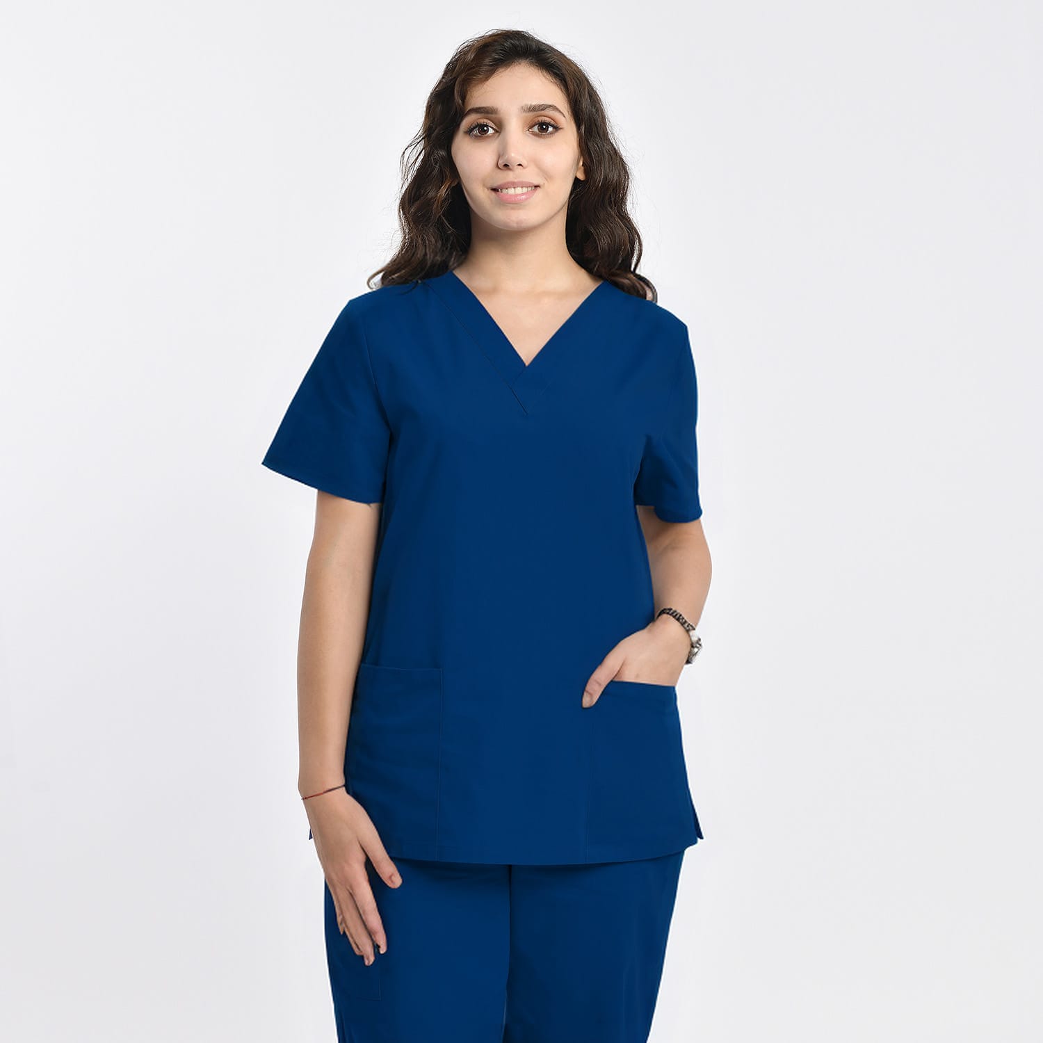 Front view of a model wearing a navy blue women’s 2-pocket V-neck scrub top, designed for healthcare professionals.