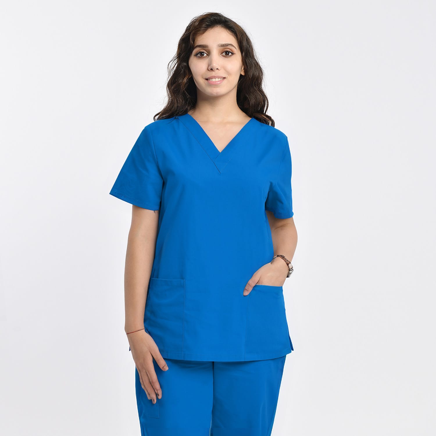 Front view of a model wearing a blue women’s 2-pocket V-neck scrub top, perfect for healthcare professionals.