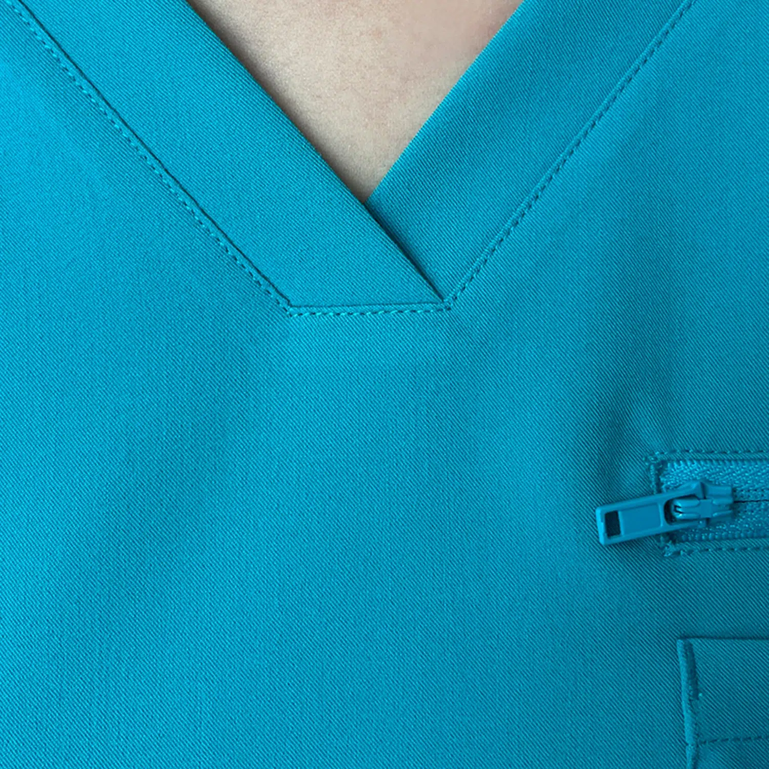 Back view of women’s teal surgical gown top with a clean, professional look, featuring a secure pocket.